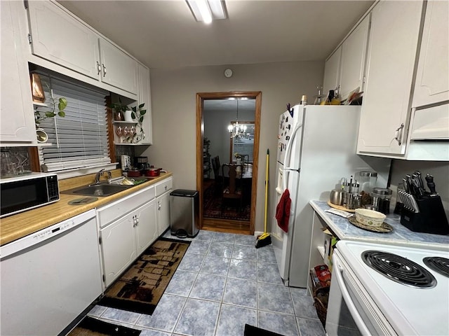 kitchen with white cabinets, white appliances, light tile patterned flooring, and sink