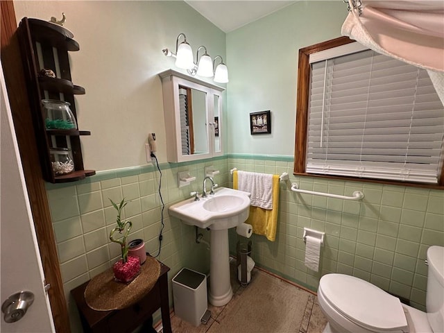 bathroom with tile patterned flooring, tile walls, and toilet