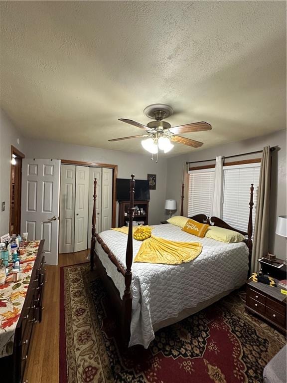 bedroom featuring a textured ceiling, ceiling fan, and dark wood-type flooring