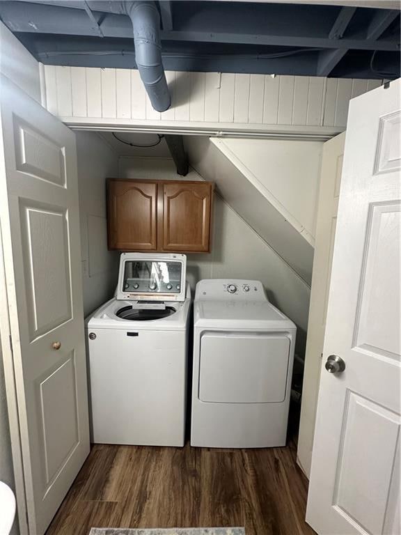 washroom with dark hardwood / wood-style flooring, washer and clothes dryer, and cabinets