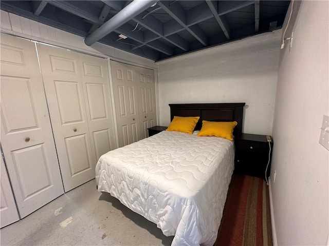 bedroom with concrete floors and multiple closets