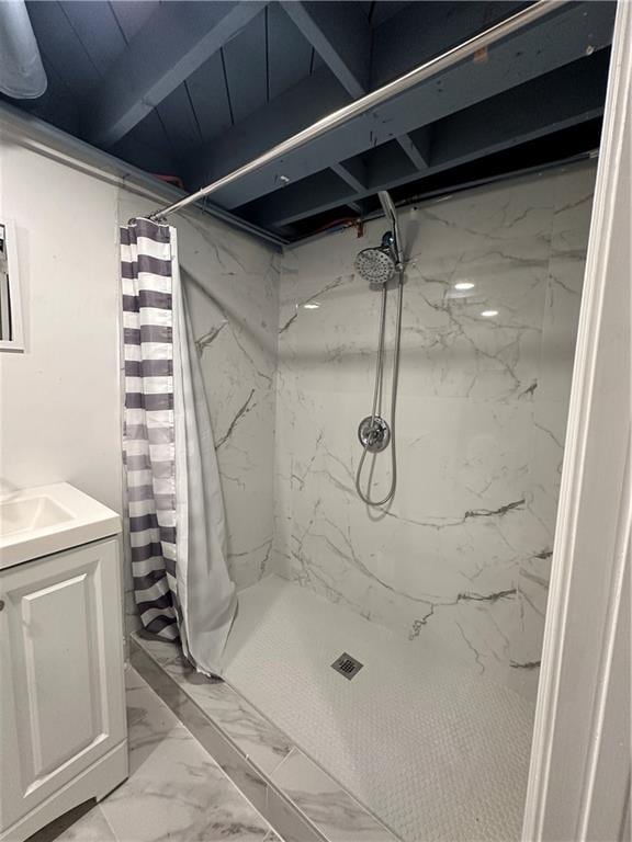 bathroom with beamed ceiling, a shower with curtain, and vanity