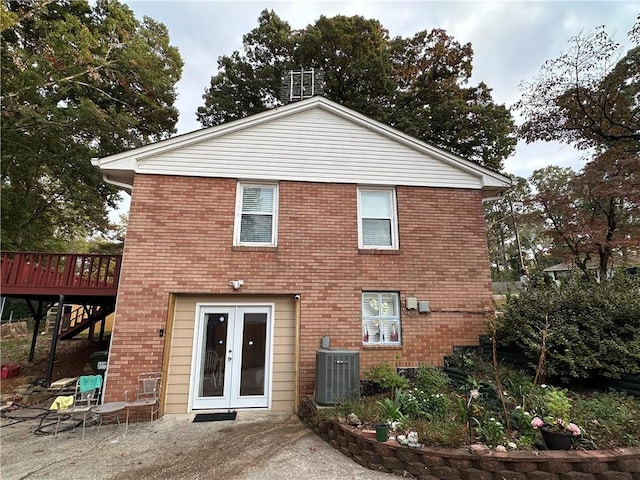 rear view of house with french doors, cooling unit, and a deck