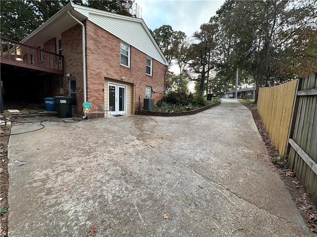 view of home's exterior featuring french doors, a deck, and central air condition unit