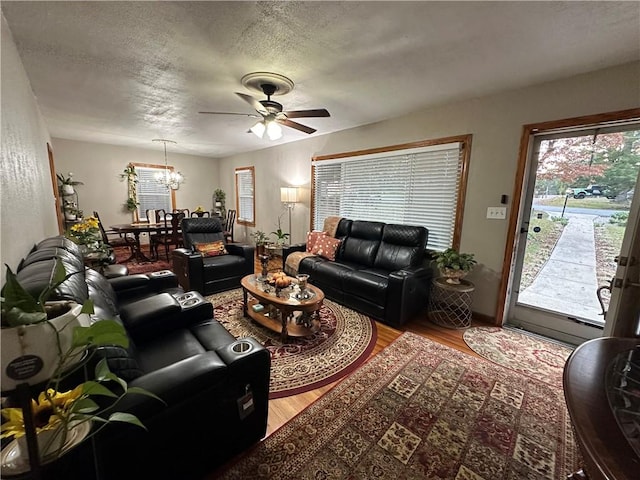 living room with a textured ceiling, ceiling fan with notable chandelier, and hardwood / wood-style flooring