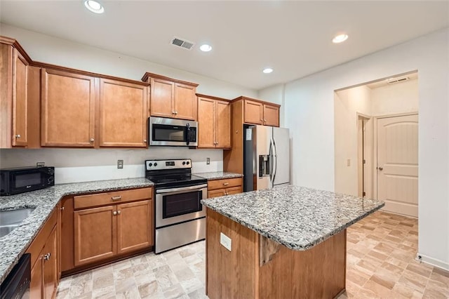kitchen featuring a kitchen island, visible vents, brown cabinets, and appliances with stainless steel finishes