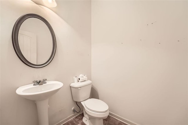 bathroom with toilet and baseboards