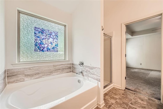 full bathroom with a wealth of natural light, a shower stall, and a garden tub