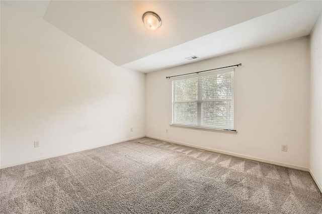 carpeted spare room featuring visible vents and baseboards