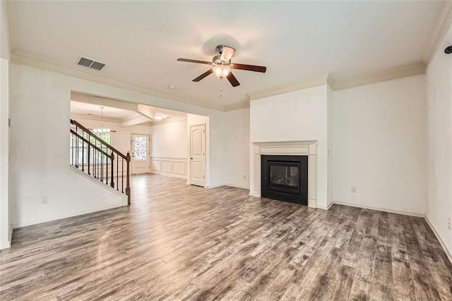 unfurnished living room with a glass covered fireplace, ceiling fan with notable chandelier, crown molding, and wood finished floors
