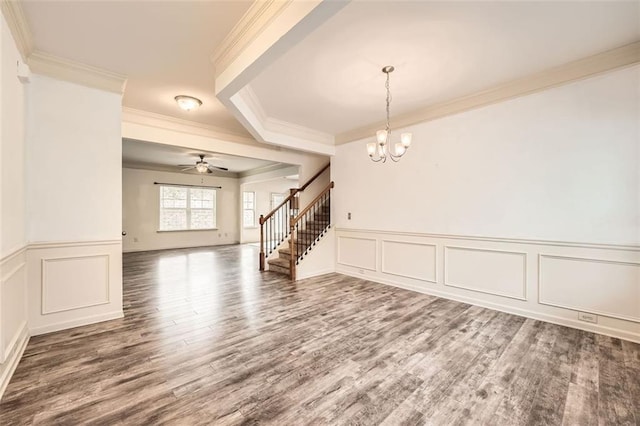 interior space featuring crown molding, a decorative wall, wood finished floors, and stairs