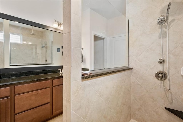 bathroom with vanity and a tile shower