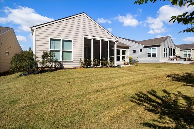 rear view of property with a sunroom and a yard