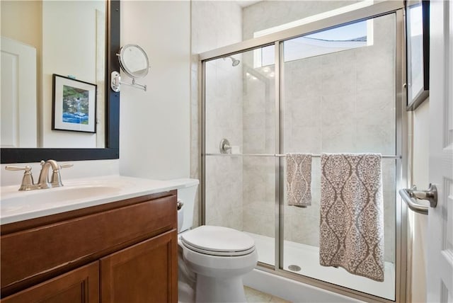 bathroom with walk in shower, vanity, and toilet