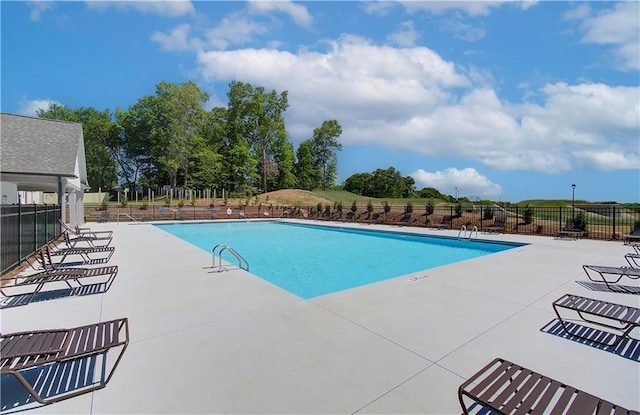 community pool with fence and a patio