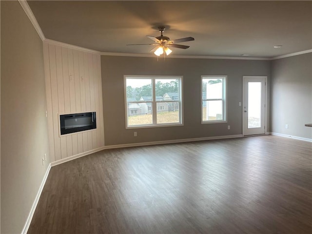 unfurnished living room with wood finished floors, baseboards, ceiling fan, ornamental molding, and heating unit