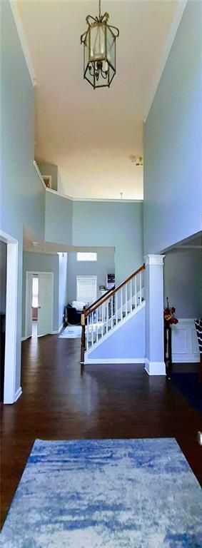 stairs featuring a chandelier, a towering ceiling, and wood-type flooring