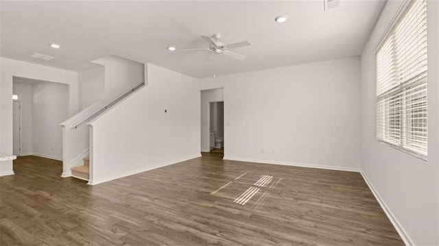 unfurnished living room featuring ceiling fan and dark hardwood / wood-style flooring