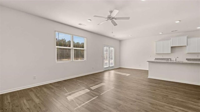 unfurnished living room with ceiling fan and dark hardwood / wood-style floors