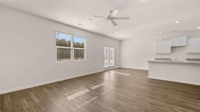unfurnished living room with baseboards, recessed lighting, a ceiling fan, visible vents, and dark wood finished floors