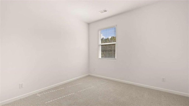 empty room featuring visible vents, baseboards, and carpet