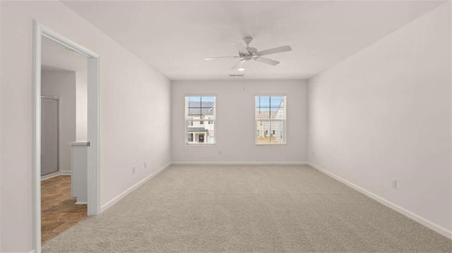 unfurnished room featuring light colored carpet and ceiling fan