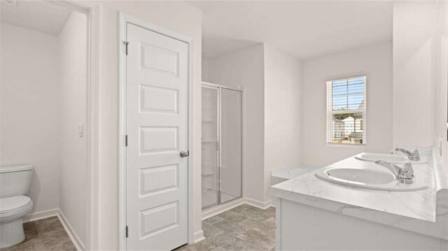 full bathroom featuring a sink, toilet, a shower stall, and baseboards