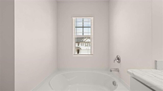 bathroom with vanity and a garden tub