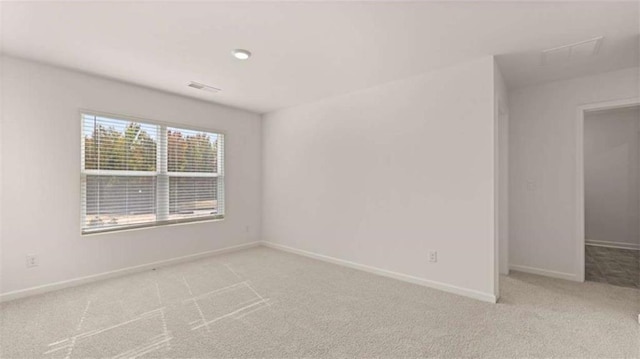 spare room with visible vents, baseboards, and carpet