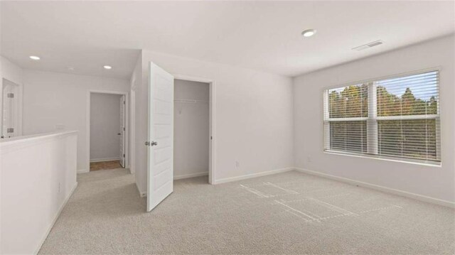 unfurnished bedroom with visible vents, baseboards, recessed lighting, and light carpet