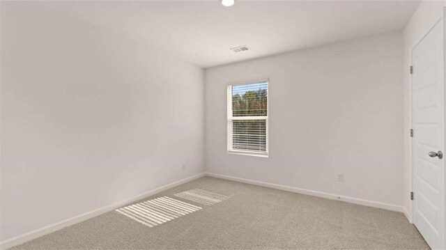 empty room with visible vents, baseboards, and light colored carpet