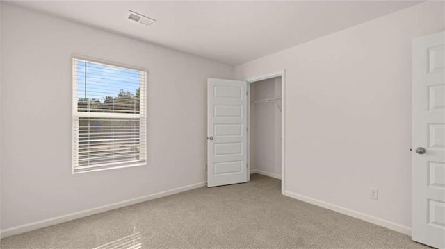 unfurnished bedroom featuring light colored carpet and a closet