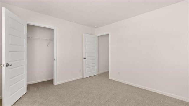 unfurnished bedroom with light carpet and a closet