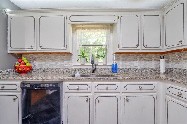 kitchen with black dishwasher, white cabinetry, backsplash, and sink