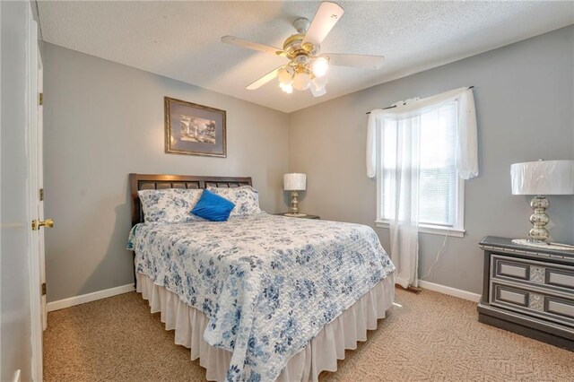 carpeted bedroom featuring a textured ceiling and ceiling fan