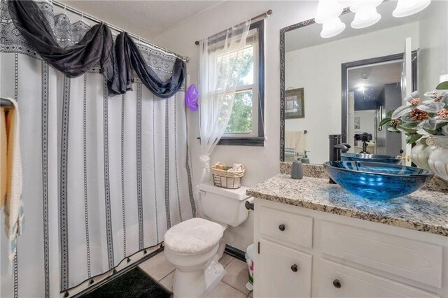 bathroom featuring a shower with shower curtain, tile patterned flooring, toilet, and vanity