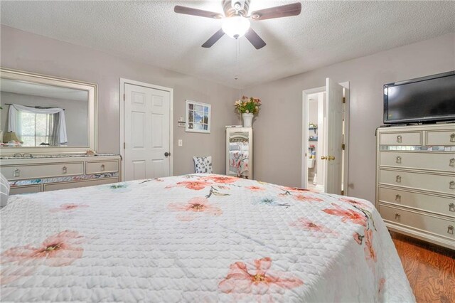 bedroom with ceiling fan, dark hardwood / wood-style flooring, and a textured ceiling