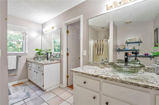 bathroom featuring a textured ceiling, vanity, and tile patterned floors