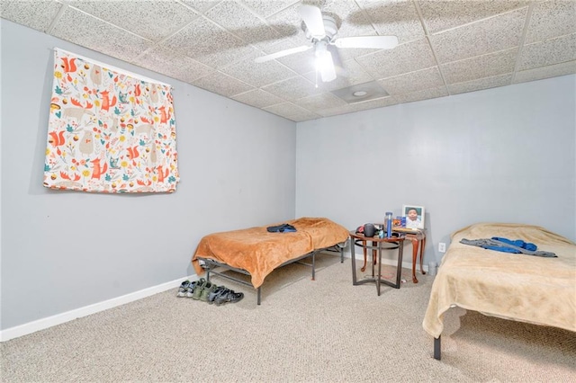 bedroom with a paneled ceiling, ceiling fan, and carpet