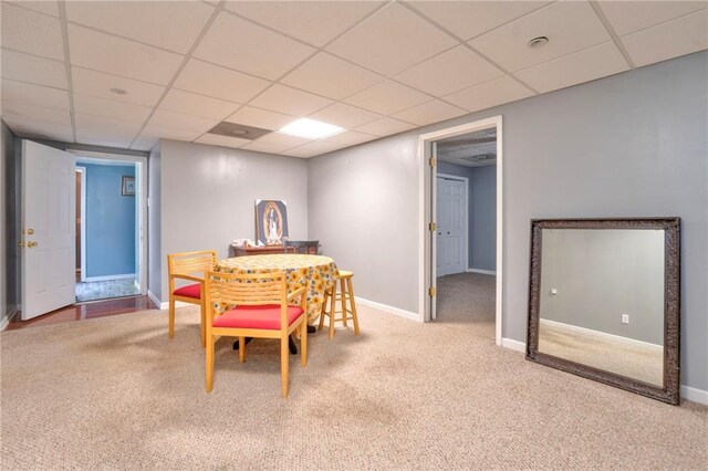 carpeted dining room featuring a drop ceiling