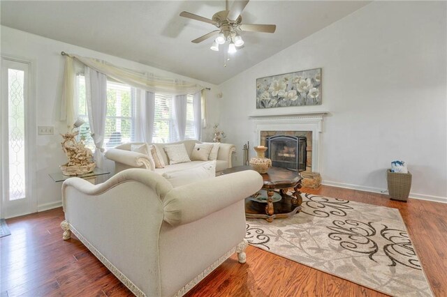 living room featuring lofted ceiling, hardwood / wood-style floors, ceiling fan, and a tile fireplace