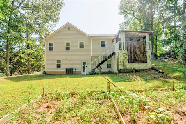 back of property with a yard and central AC