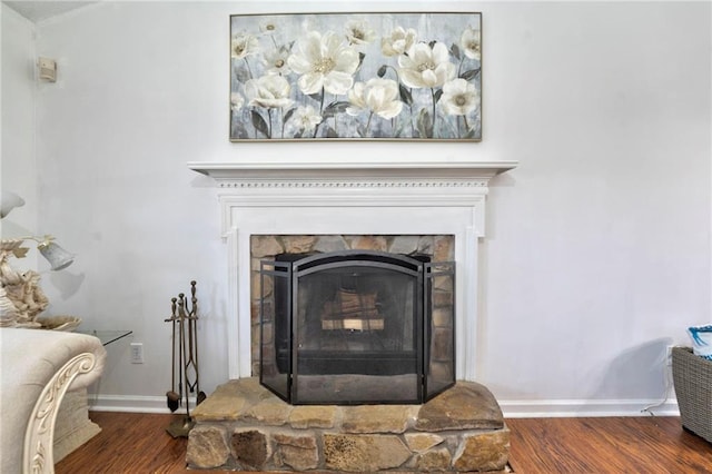 room details featuring hardwood / wood-style flooring and a stone fireplace