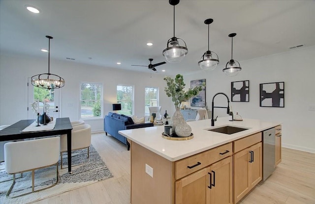 kitchen with visible vents, a sink, light countertops, dishwasher, and open floor plan