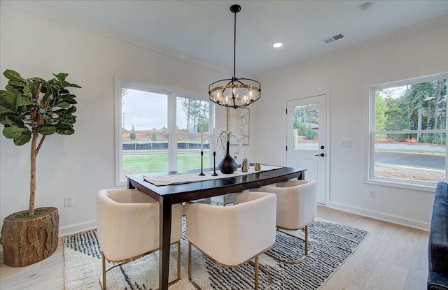 dining room with baseboards, light wood-type flooring, a wealth of natural light, and a chandelier