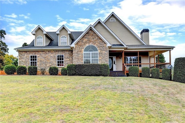 39 Legendary Dr, Hoschton, GA 30548 - view of front facade with stone siding, covered porch, a front yard, and a chimney