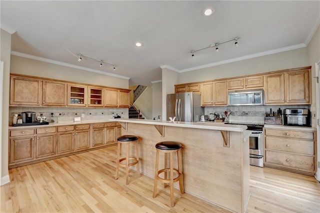 39 Legendary Dr, Hoschton, GA 30548 - kitchen featuring stainless steel appliances, a kitchen bar, rail lighting, backsplash, and ornamental molding