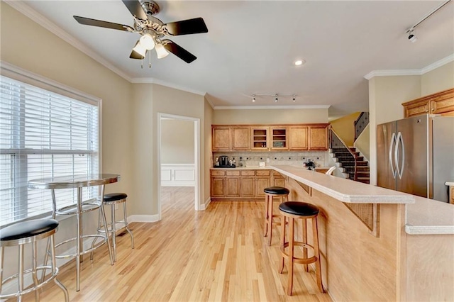 39 Legendary Dr, Hoschton, GA 30548 - kitchen featuring track lighting, freestanding refrigerator, a breakfast bar area, light countertops, and crown molding