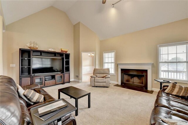 39 Legendary Dr, Hoschton, GA 30548 - carpeted living area featuring a fireplace with flush hearth, high vaulted ceiling, and a chandelier