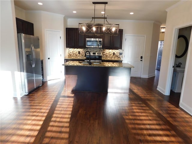 kitchen with stainless steel appliances, dark wood-style flooring, backsplash, dark stone countertops, and crown molding